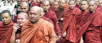 Buddhist monks, accompanied by civilians, march on a street in a protest against the military government in Yangon