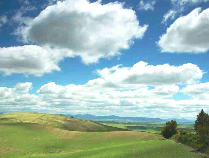 Clouds over rolling green hills