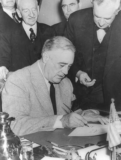 Franklin Roosevelt signing declaration of war against Japan