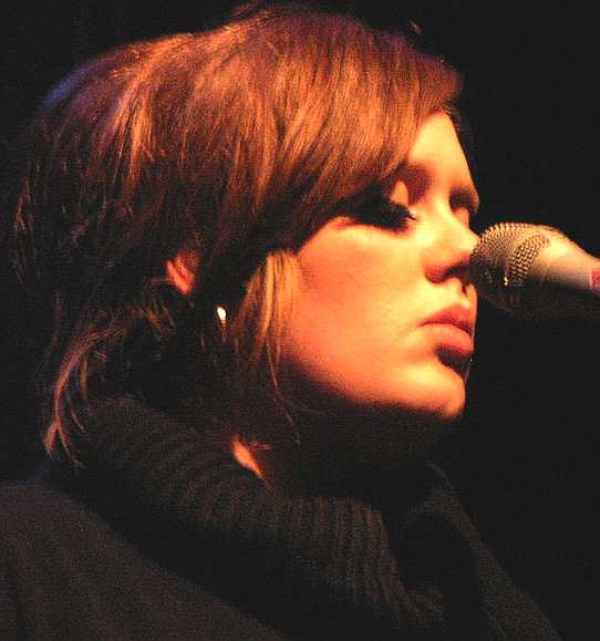 Adele singing into microphone on stage 2009