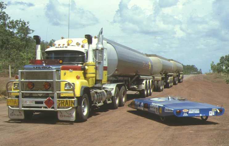 Denis Bartell's - Spirit of Adelaide solar car in 1986 next to a Mack road train