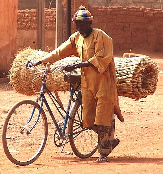 Using a bicycle for transport, typical indian and african daily picture of sustainability
